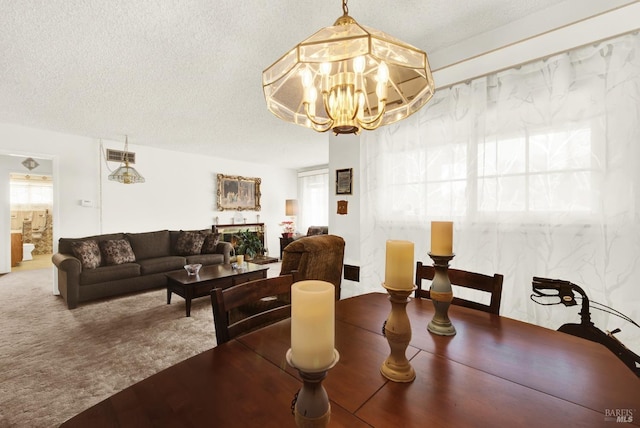 carpeted dining area featuring visible vents, a textured ceiling, and an inviting chandelier