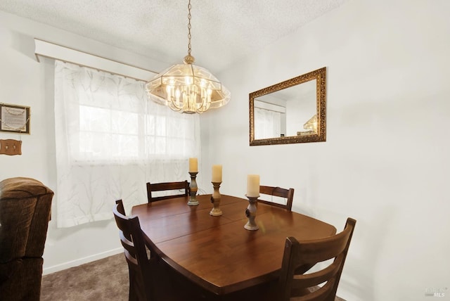 carpeted dining room featuring a notable chandelier, baseboards, and a textured ceiling