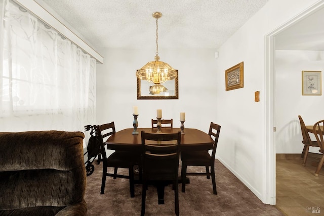 dining space with baseboards, a chandelier, and a textured ceiling