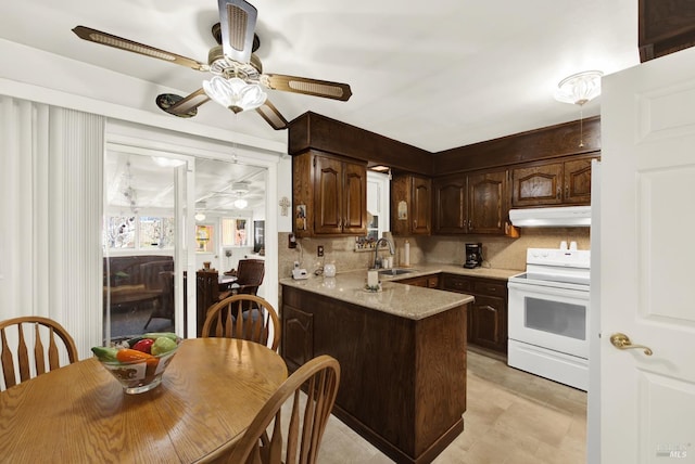 kitchen with white electric stove, under cabinet range hood, a peninsula, light countertops, and dark brown cabinets