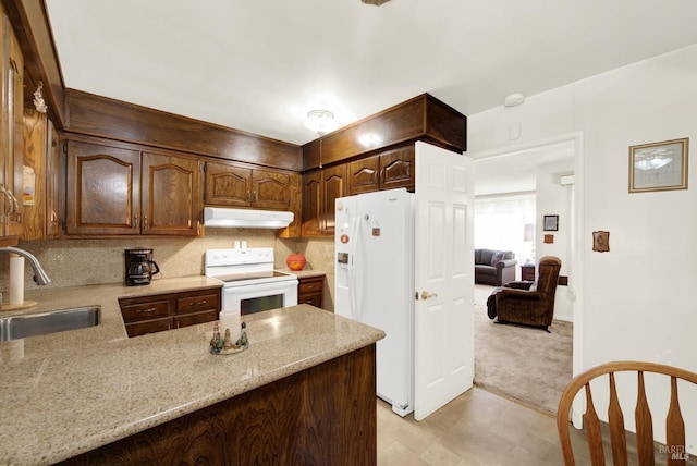 kitchen featuring light carpet, a sink, a peninsula, white appliances, and under cabinet range hood