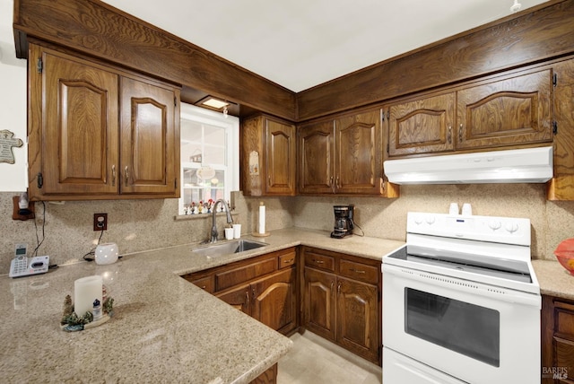 kitchen featuring white range with electric stovetop, tasteful backsplash, a sink, light stone countertops, and under cabinet range hood