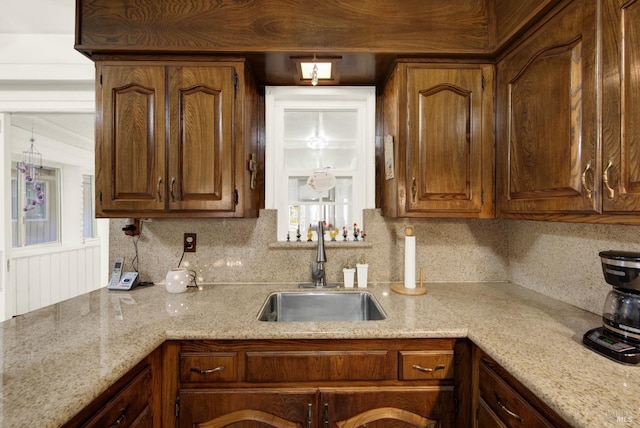 kitchen with tasteful backsplash, brown cabinets, and a sink