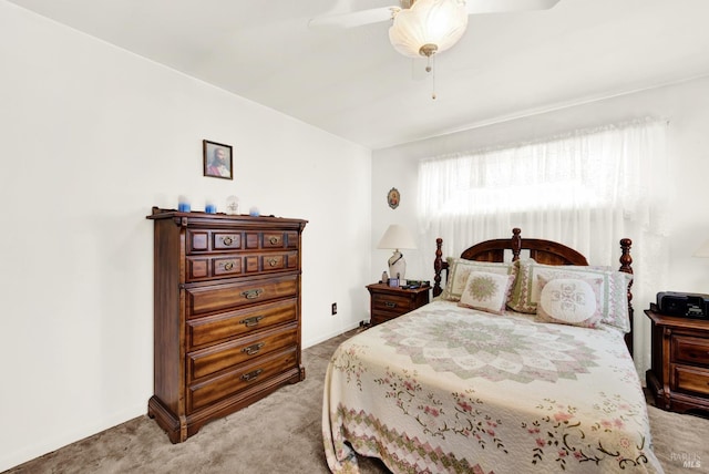 carpeted bedroom with ceiling fan and baseboards