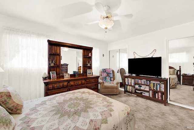 bedroom with a ceiling fan, a closet, and light colored carpet