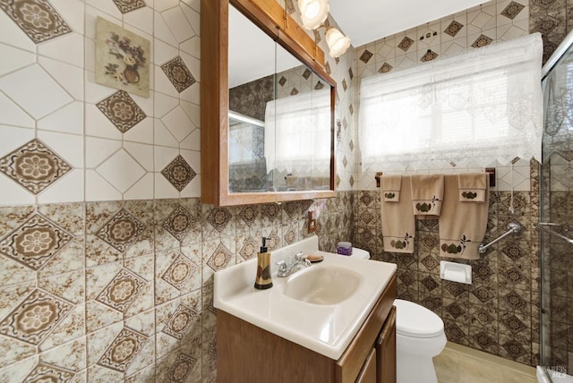 bathroom with tile walls, toilet, an enclosed shower, vanity, and tile patterned flooring