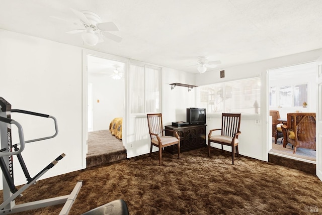 sitting room featuring ceiling fan and dark colored carpet