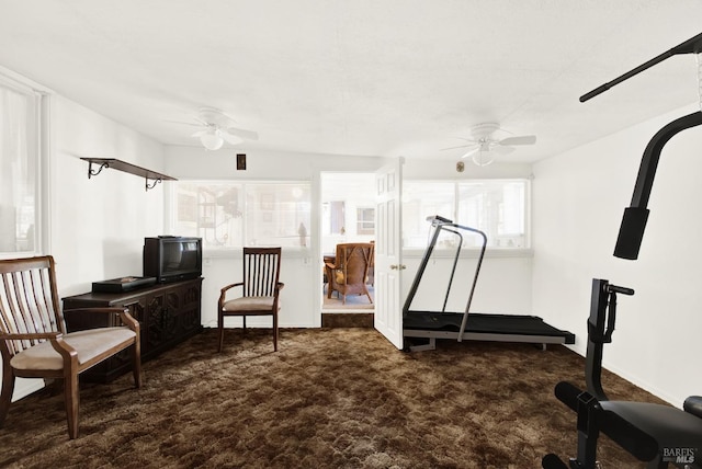 exercise room featuring dark carpet and a ceiling fan