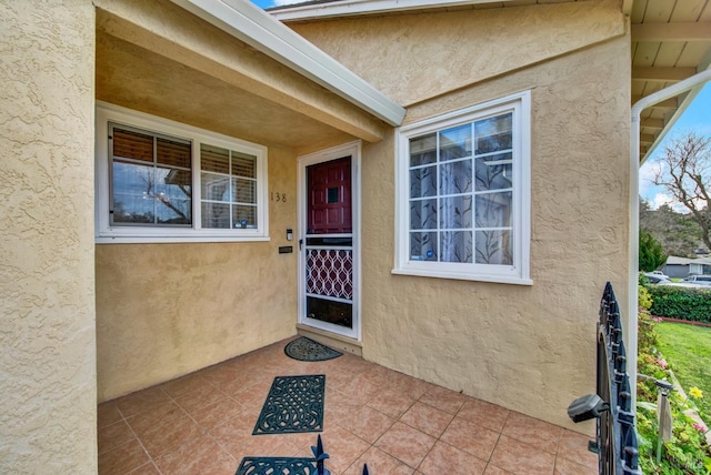 doorway to property featuring a patio area and stucco siding