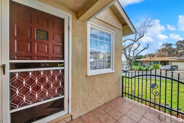 property entrance featuring a lawn and stucco siding