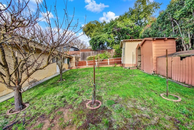 view of yard with a shed, an outdoor structure, and a fenced backyard