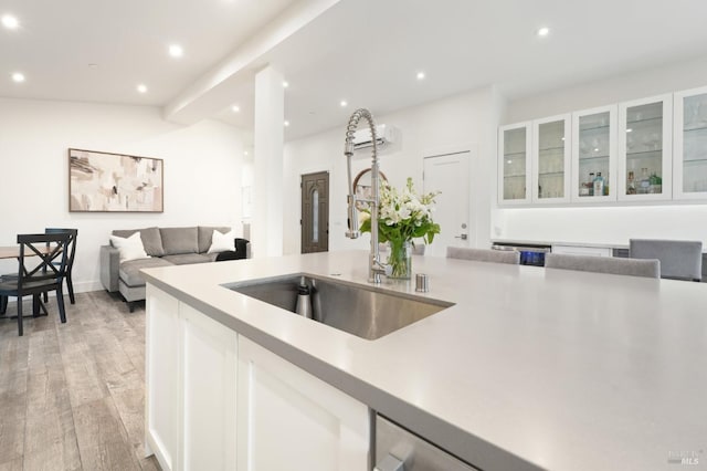 kitchen featuring white cabinets, sink, and light hardwood / wood-style floors