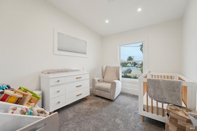 carpeted bedroom featuring a nursery area