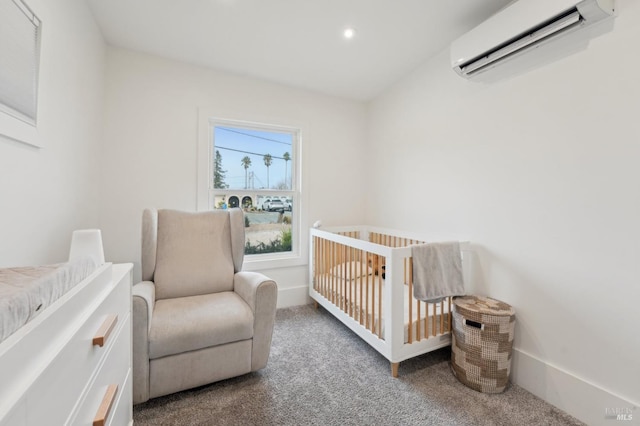 bedroom featuring an AC wall unit, a nursery area, and carpet floors