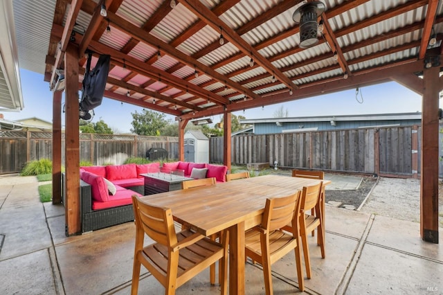 view of patio / terrace featuring ceiling fan, an outdoor living space, and a storage unit