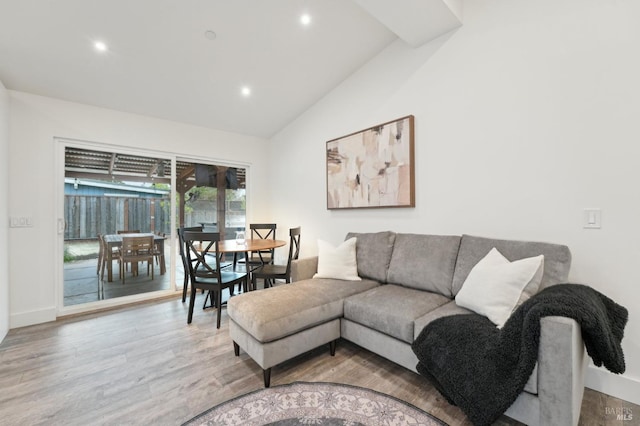 living room featuring light hardwood / wood-style floors and high vaulted ceiling