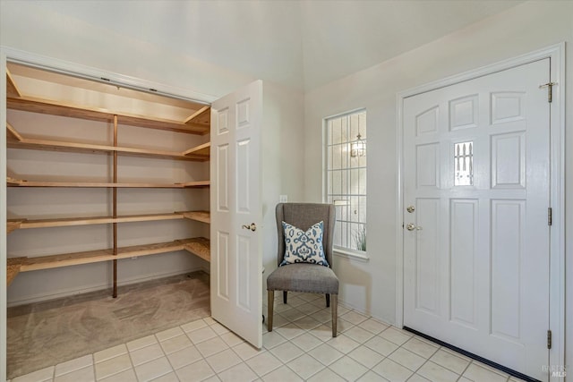 entryway with light carpet, baseboards, and light tile patterned flooring