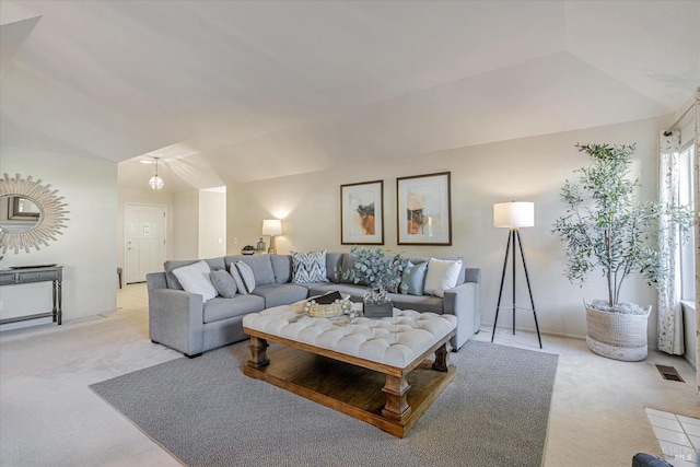 living room with lofted ceiling, carpet flooring, and visible vents