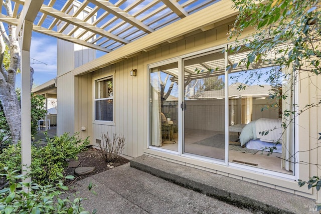 view of exterior entry featuring a pergola