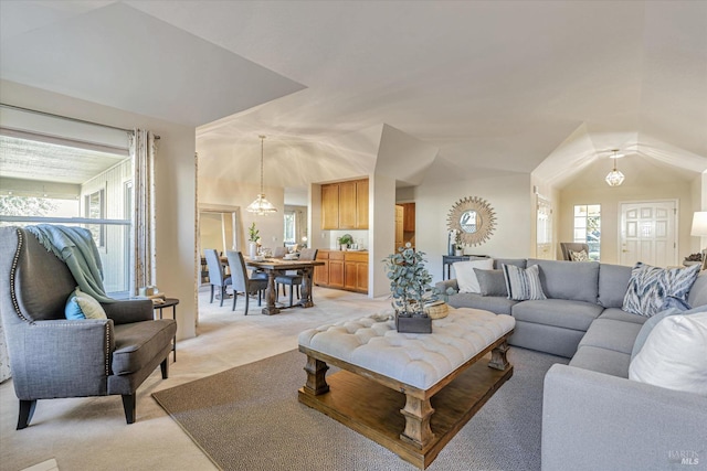 living room with light carpet and an inviting chandelier