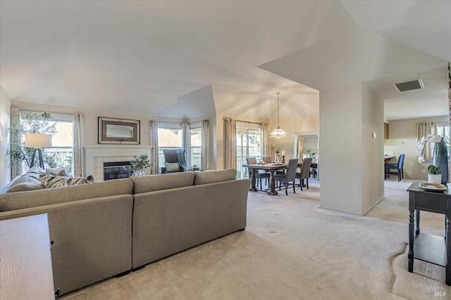 living room with a fireplace, a healthy amount of sunlight, visible vents, and light carpet