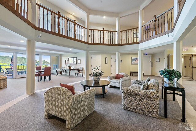 carpeted living room with a high ceiling