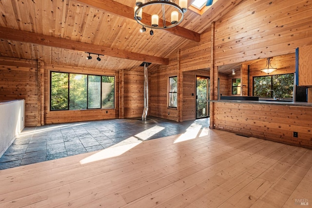 unfurnished living room with wood-type flooring, wooden walls, wood ceiling, and lofted ceiling with beams