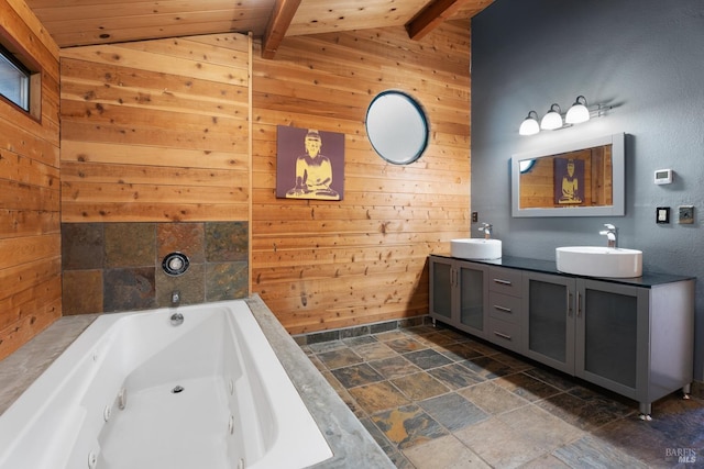 full bath featuring stone tile floors, lofted ceiling with beams, wooden walls, and a sink