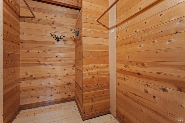 bonus room featuring wood walls, light wood-style floors, and a sauna
