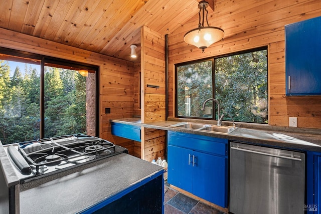 kitchen featuring stainless steel dishwasher, blue cabinets, wood walls, and sink