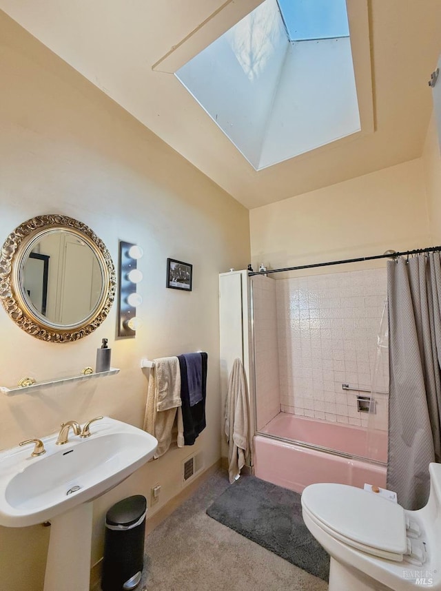 full bathroom with sink, toilet, a skylight, and tiled shower / bath