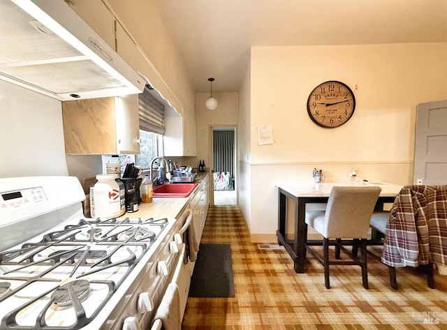 kitchen with sink, pendant lighting, and gas stove