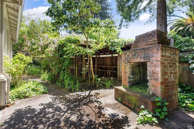 view of patio featuring an outdoor brick fireplace