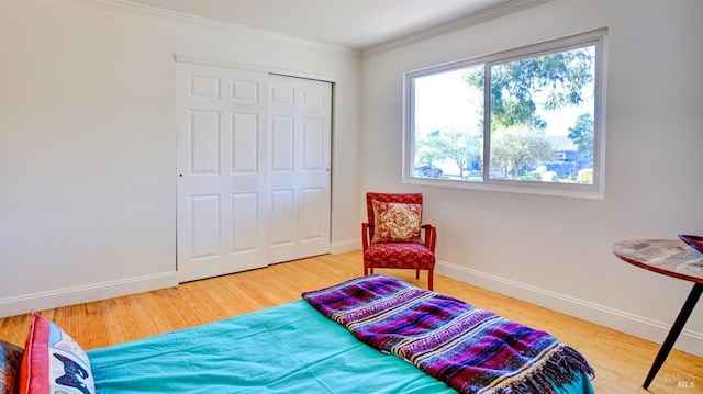 bedroom with a closet, ornamental molding, and hardwood / wood-style flooring