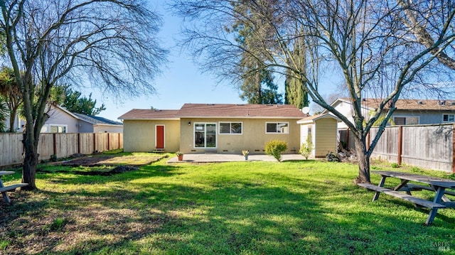 back of property with a yard and a patio