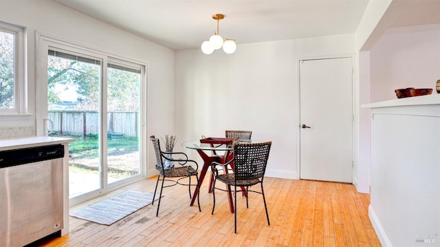 dining space with light wood-type flooring and a notable chandelier