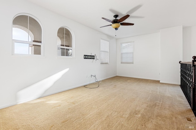 empty room with ceiling fan and light carpet