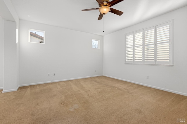 carpeted spare room featuring ceiling fan