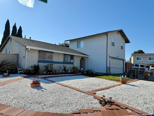 view of front of property featuring a gate, fence, and stucco siding