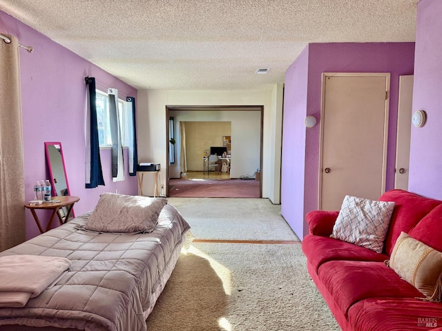 carpeted bedroom with visible vents and a textured ceiling