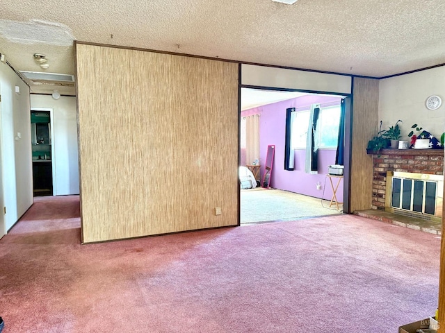 unfurnished living room featuring carpet, a brick fireplace, and a textured ceiling