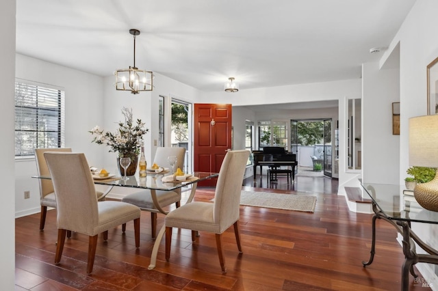 dining space with dark hardwood / wood-style flooring and a chandelier