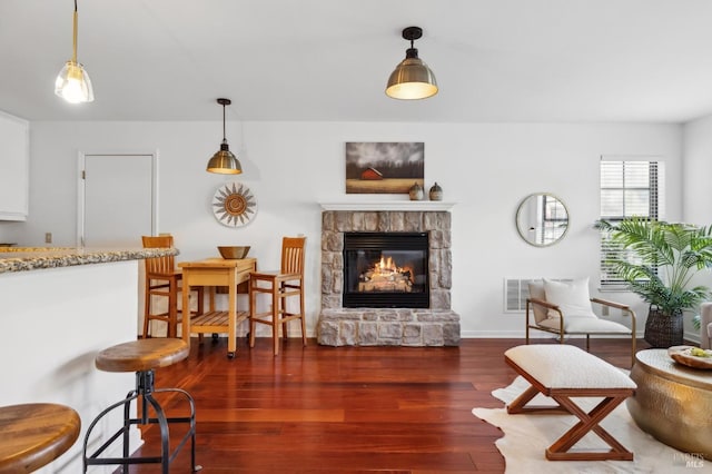 living room with a fireplace and dark hardwood / wood-style flooring