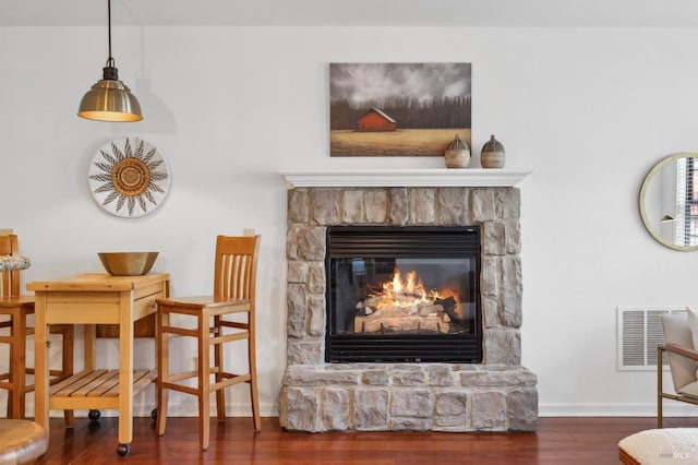 sitting room with dark hardwood / wood-style flooring and a stone fireplace