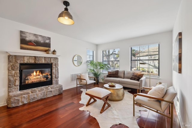 living room with dark wood-type flooring and a fireplace