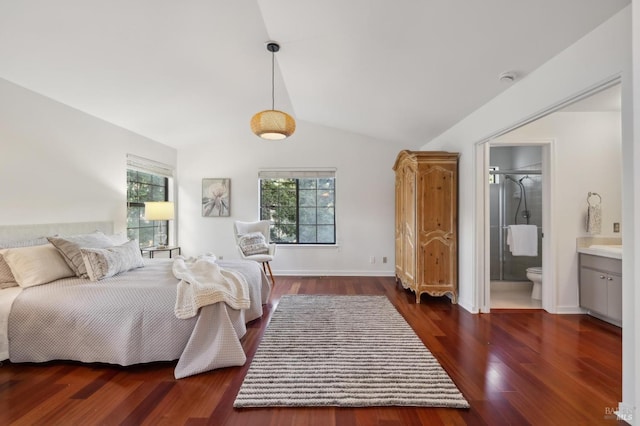 bedroom with vaulted ceiling, dark hardwood / wood-style flooring, and connected bathroom