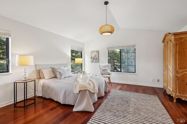 bedroom with vaulted ceiling, dark hardwood / wood-style flooring, and multiple windows