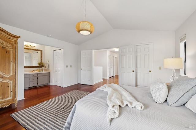 bedroom with lofted ceiling, ensuite bath, and dark hardwood / wood-style floors