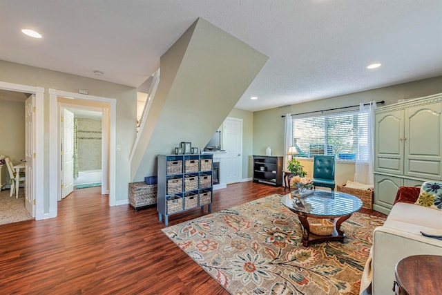 living room with a textured ceiling, dark wood-type flooring, recessed lighting, and baseboards