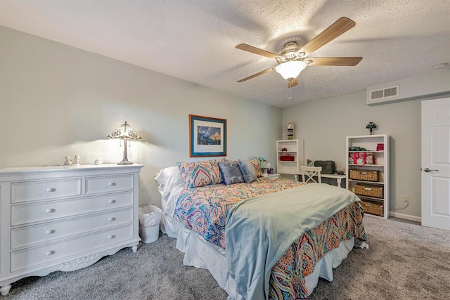 bedroom with a textured ceiling, ceiling fan, visible vents, and light colored carpet